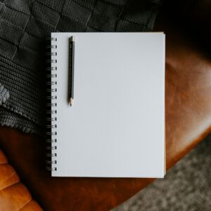 a notepad sitting on top of a brown leather chair